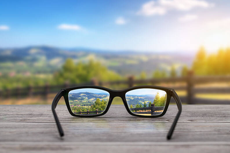 Blurry Background with Glasses on Table Seeing Clear